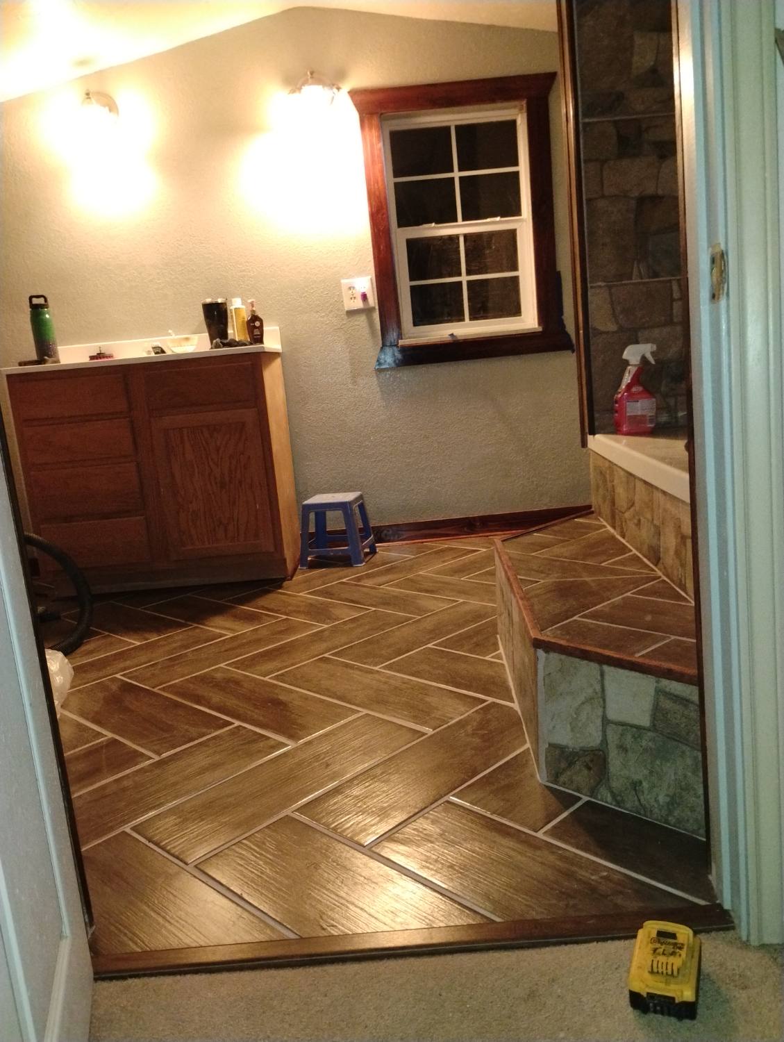 Finished wood-look tile bathroom floor in a natural stone and standard pattern